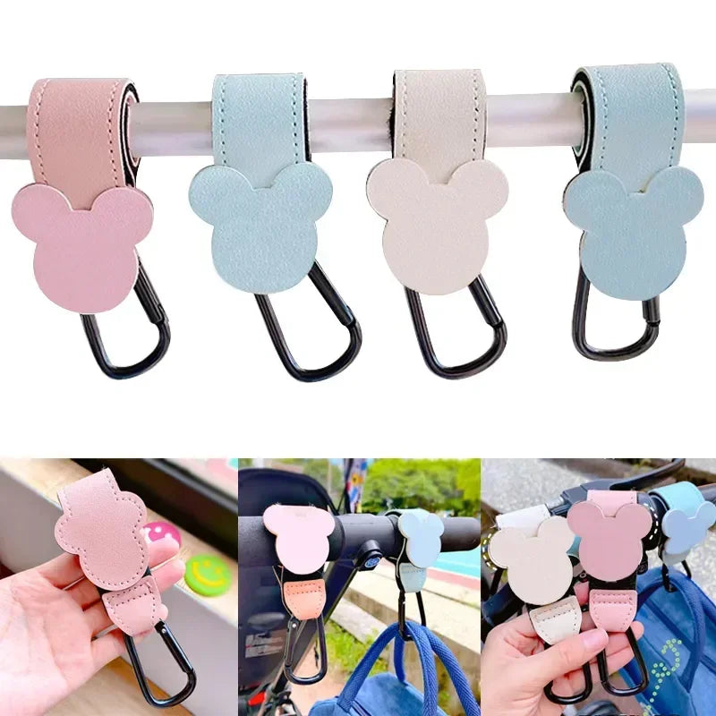 A set of pink, blue, and beige Mickey Mouse-shaped PU leather organizer hooks for strollers.