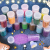 A collection of 36 colorful glitter powders in small plastic containers is displayed on a dark surface.