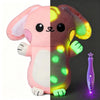 A half-and-half plush rabbit toy where one side is pink and the other is glowing green.