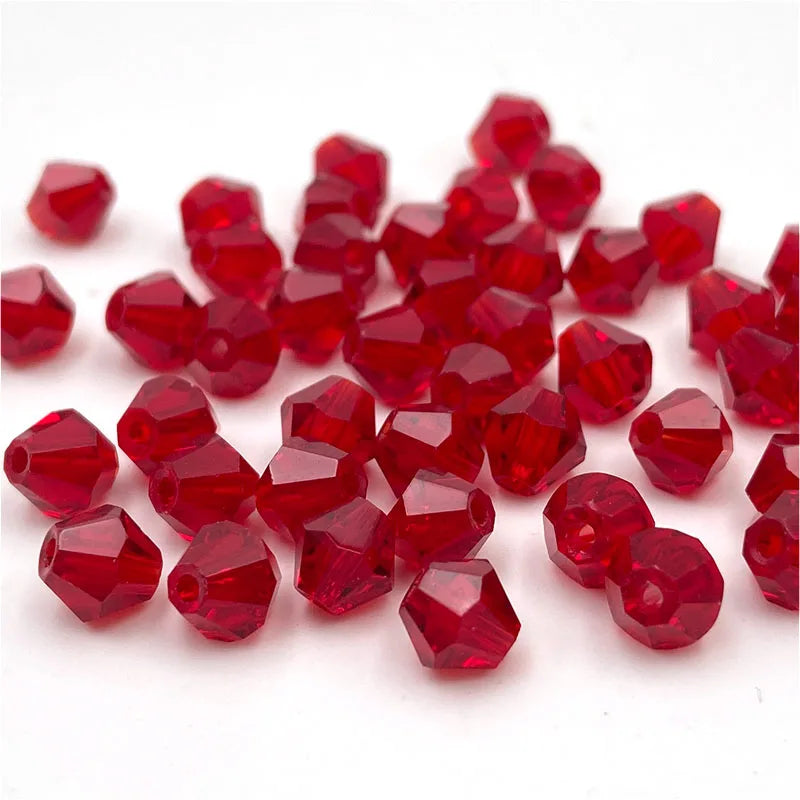 A pile of faceted red crystal glass beads in various sizes for jewelry making