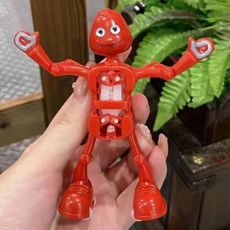 A hand holds an orange wind-up dancing robot toy with red limbs and a round head.