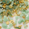 A collection of green imitation jade charms and beads in various shapes and sizes, set against a white background.