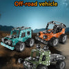Three metal off-road vehicle models built from building blocks displayed on a dirt surface.