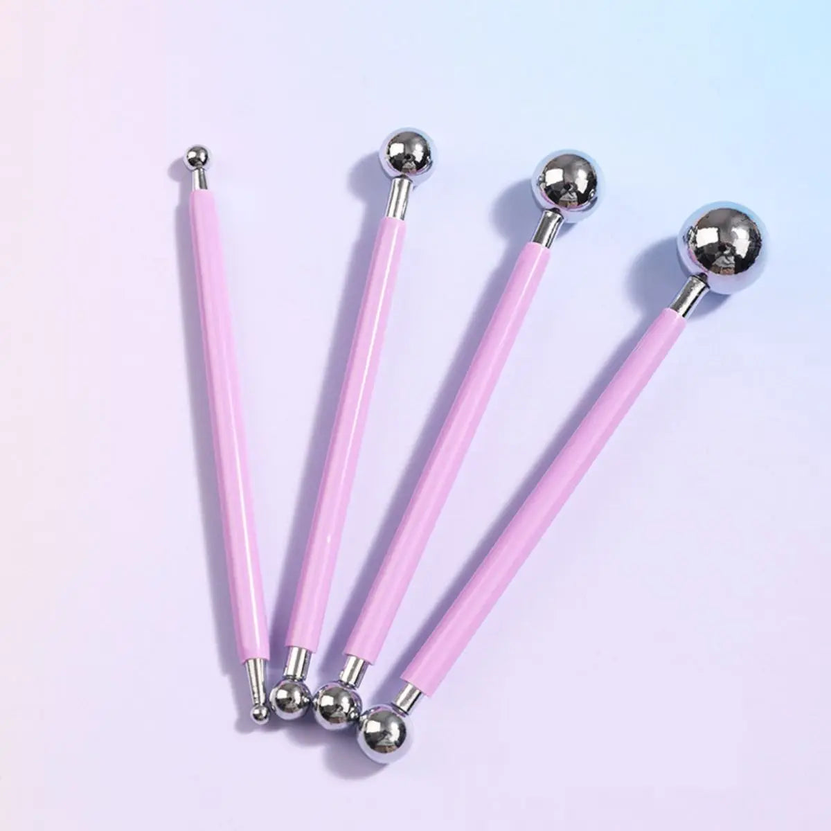 A set of four pink clay sculpting tools with silver balls for pottery and crafting