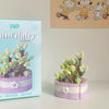 A set of miniature flower bouquets made from building blocks in purple and green colors.