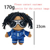 A plush doll of Eminem, XXXTentacion & Frank Ocean with black dreadlocks and sunglasses, wearing a blue shirt.