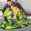 A child and adult build a green glow-in-the-dark LED race car track set for kids on a gray floor.