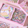 Pink box containing a sticker set of cartoon mini town diorama scenes for junk journals and scrapbooking