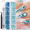 A box of blue and teal glass rhinestones, a point drill pen, and tweezers for nail art.