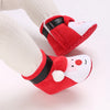 A pair of red and white animal-themed baby first walker shoes with black accents shown on a foot.