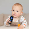 A baby is holding a lion-shaped silicone teether with remote control features.