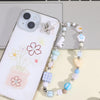 A beaded phone charm hook with various pastel colored beads and a star charm is displayed next to a white smartphone.