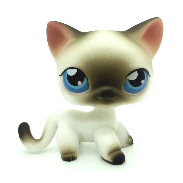 A small, white and tan Littlest Pet Shop style dog figure with large blue eyes.