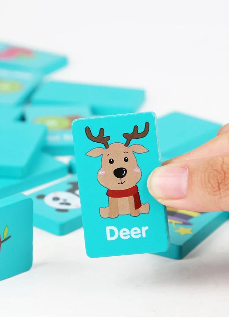 A hand holds a wooden puzzle piece featuring a deer design in blue and pink on a white background.