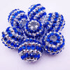 A cluster of blue and silver mixed two-tone striped resin beads shaped like spheres for jewelry making