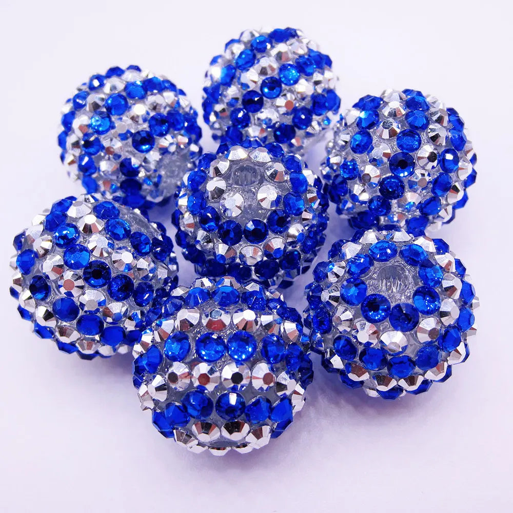 A cluster of blue and silver mixed two-tone striped resin beads shaped like spheres for jewelry making