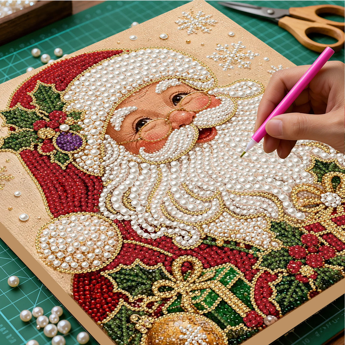 A hand is painting a Christmas Santa face using pearls and beads on a diamond painting canvas.