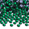 A close-up view of green and dark gray glass crystal rhinestones scattered on a white background.