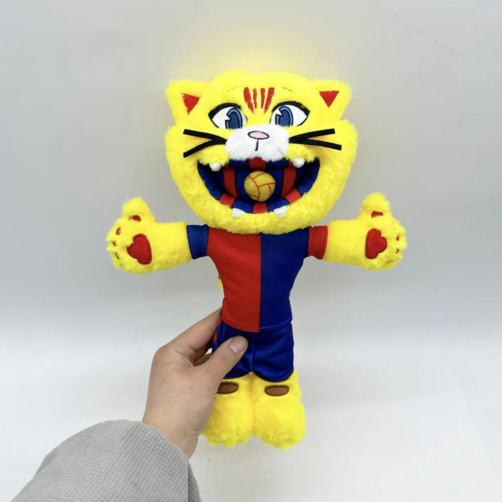 A yellow cat mascot plush toy with black stripes and a football design, held by a person's hand.