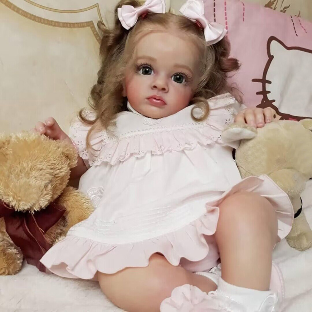 A baby doll wearing a pink dress with ruffles and accessories, sitting on a white surface.