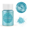 A glass jar of blue green pearl powder with a swirling texture and a pile of the same powder nearby.