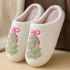 Pair of white plush indoor slippers decorated with pink and green Christmas trees