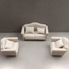 A miniature striped sofa and pillow set for a dollhouse displayed on a gray surface.