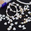Assorted white pearl beading beads and accessories including flowers, butterflies, and stars
