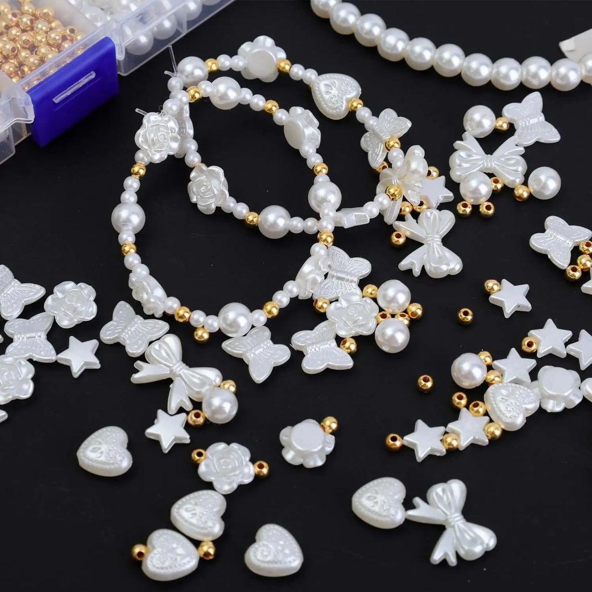 Assorted white pearl beading beads and accessories including flowers, butterflies, and stars
