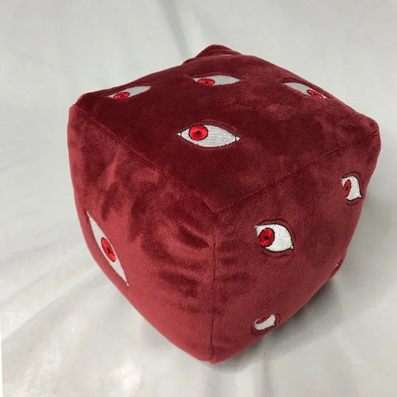 A deep red plush figure shaped like a cube with multiple white and red eyes.