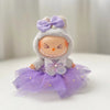 A cute doll wearing a purple bow and tulle skirt with glittery accents.
