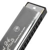A close-up view of a 24-hole C tone tremolo harmonica with a silver and black hard case.