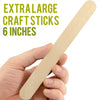 A hand holds an extra-large 6-inch wooden craft stick for mixing paint or epoxy resin.