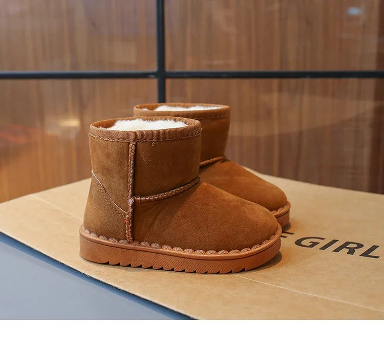 A pair of brown suede winter boots with white faux fur lining displayed on a cardboard box.