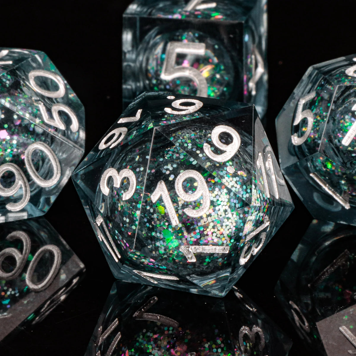A close-up of a set of polyhedral dice with a galaxy finish, showing various angles and facets.