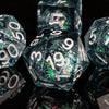 A close-up of a set of polyhedral dice with a galaxy finish, showing various angles and facets.