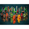 A collection of colorful spices and herbs displayed on a dark slate board, arranged with spoons.