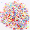 A pile of colorful polymer clay sprinkles mix in various shades including pink, blue, yellow, and red.