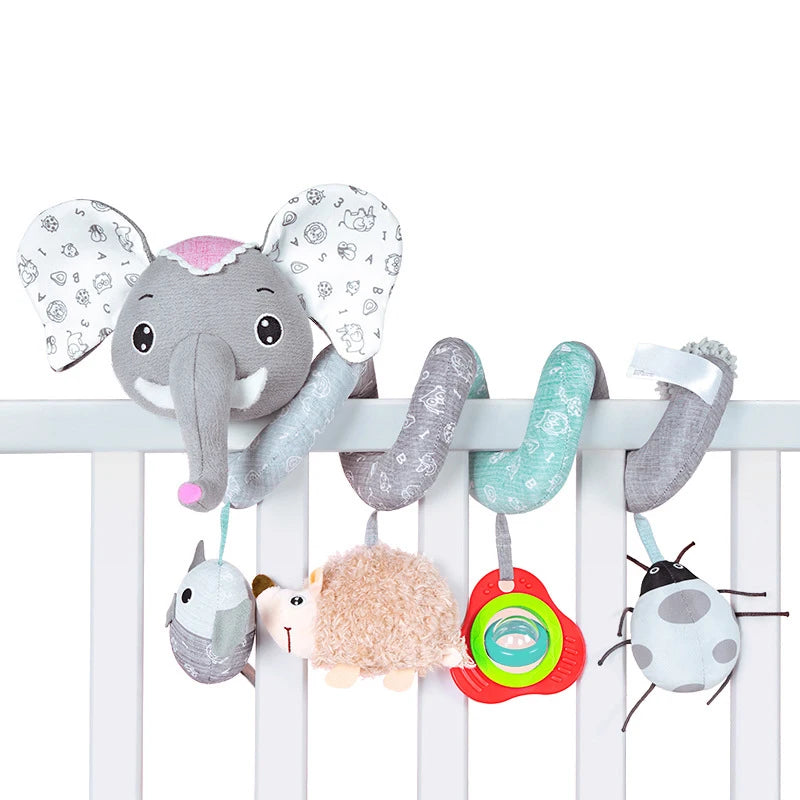 Un ensemble de galets et miroirs thématiques éléphants et animaux, suspendus sur la barrière d'un berceau en bois blanc.