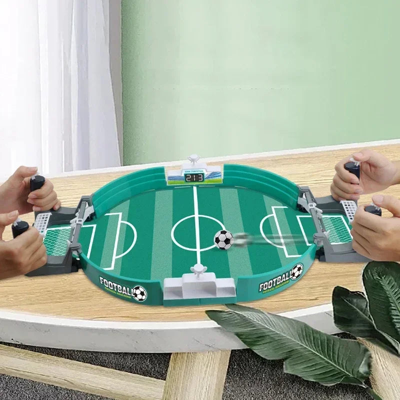 A portable tabletop foosball game with green and white components is set up on a wooden table.