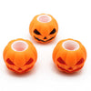 Three small orange pumpkin squishy fidget toys with carved faces and pink interiors
