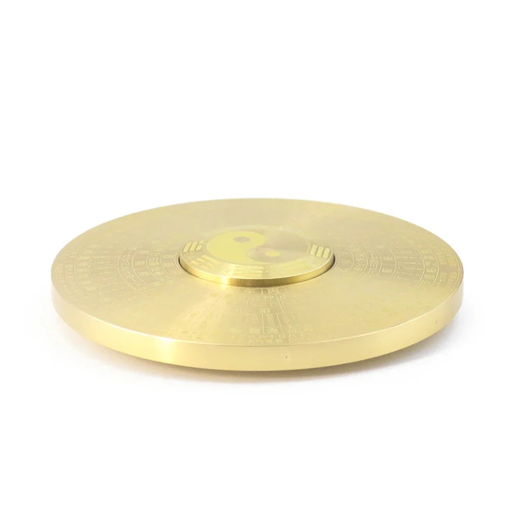 A round brass Yin Yang compass decor with a polished finish.