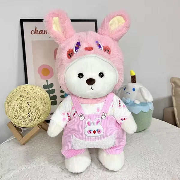 A pink handmade plush bear cosplay doll with large ears and a white body sitting on a white surface.