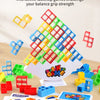 A pile of colorful wooden stacking blocks is shown with a pyramid structure, alongside game cards and a wooden table.