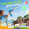 A boy is using a blue electric water blaster to shoot a red balloon, with a green balloon floating nearby.