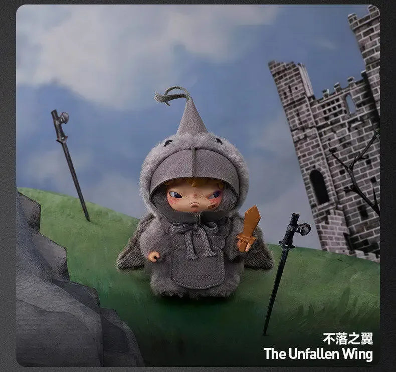 A gray plush doll wearing a hood stands in front of a stone castle backdrop.