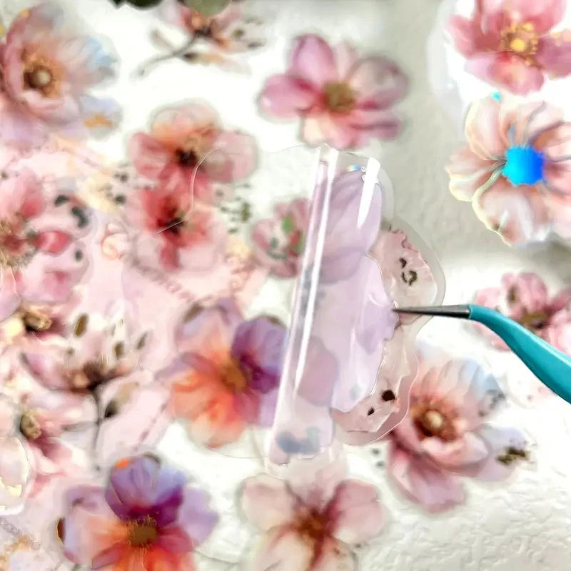 Pink floral hot stamp stickers scattered on a white background