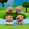 Three cute mini hippo resin figurines in various poses sitting on green grass and blue accents.