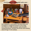 A detailed diorama showing mini tableware, sushi plates, and side dishes arranged on a wooden stage.