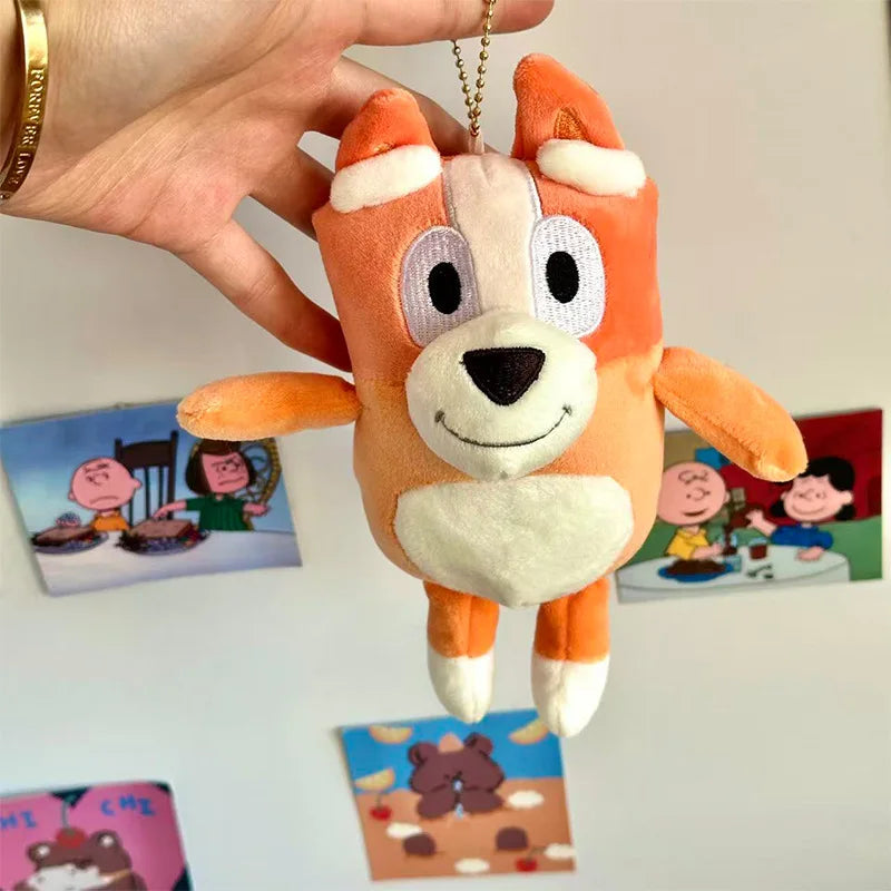 An orange and white plush toy resembling a dog, held by a hand against a background of colorful cards.